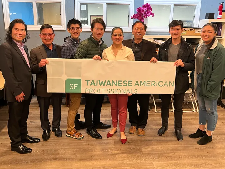Eight people holding a banner reading SF Taiwanese American Professionals.